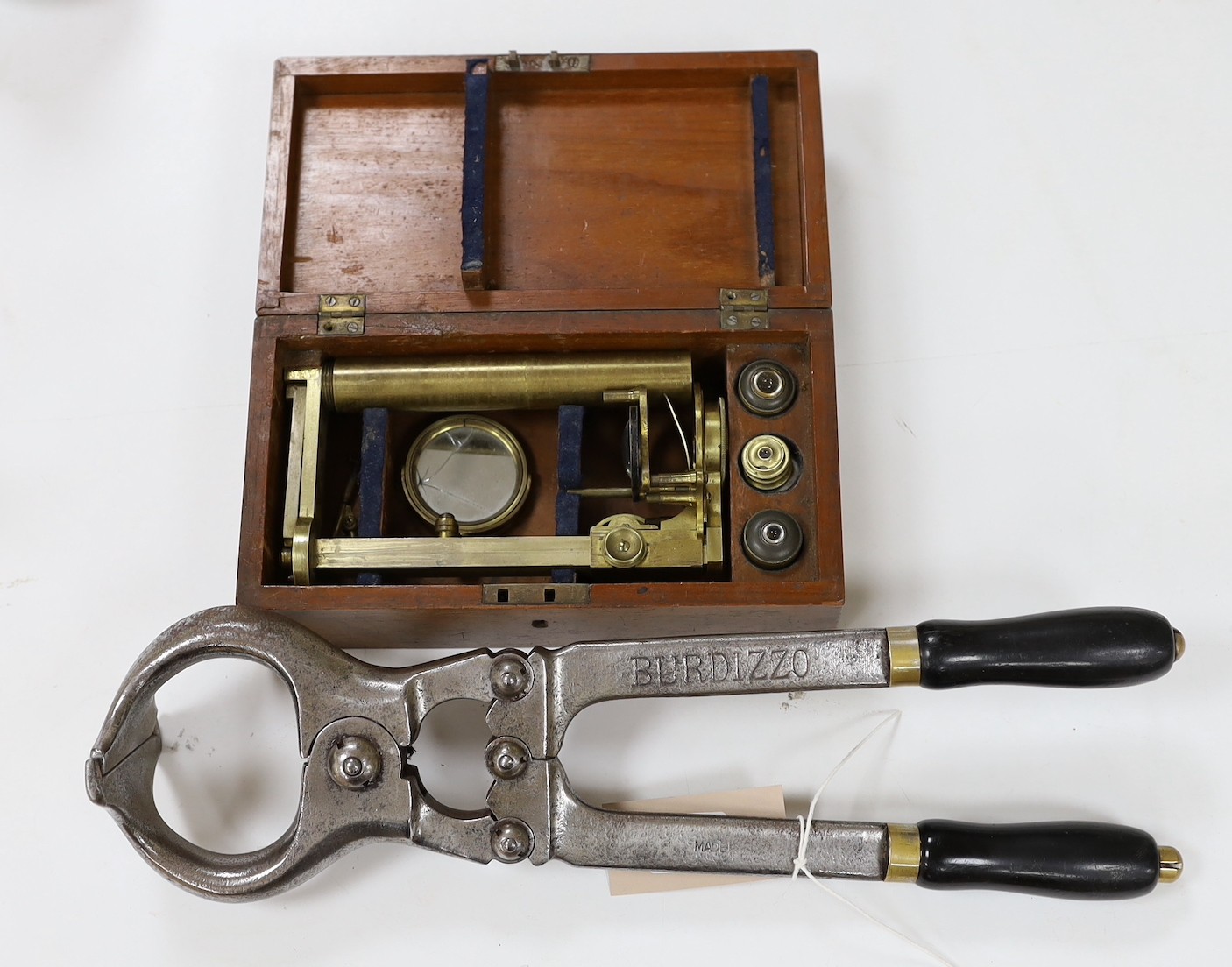 A mahogany cased microscope and a pair of Burdizzo tail dockers, 40cms long